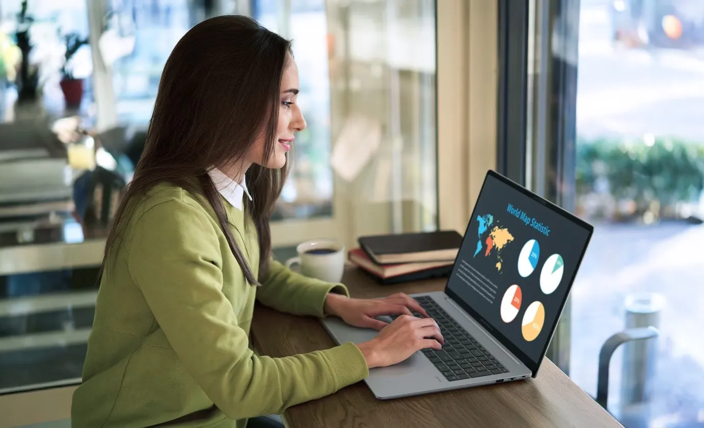 Mujer trabajando con una ASUS ExpertBook P3 junto a una ventana