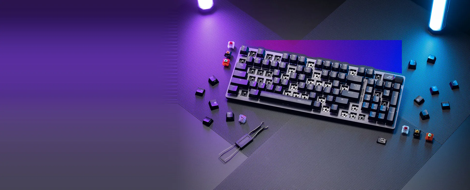 Teclado ASUS ROG Strix Scope II 96 Wireless con switches intercambiables sobre un escritorio iluminado