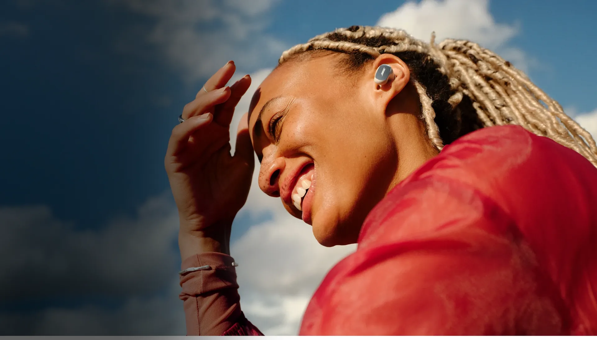Mujer sonriendo con Bose QuietComfort Ultra Earbuds blancos
