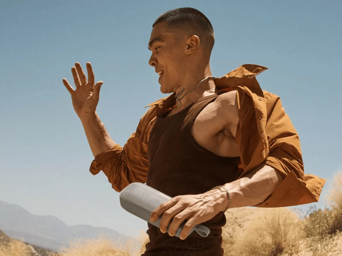 Hombre bailando al aire libre con un SoundLink Flex en la mano
