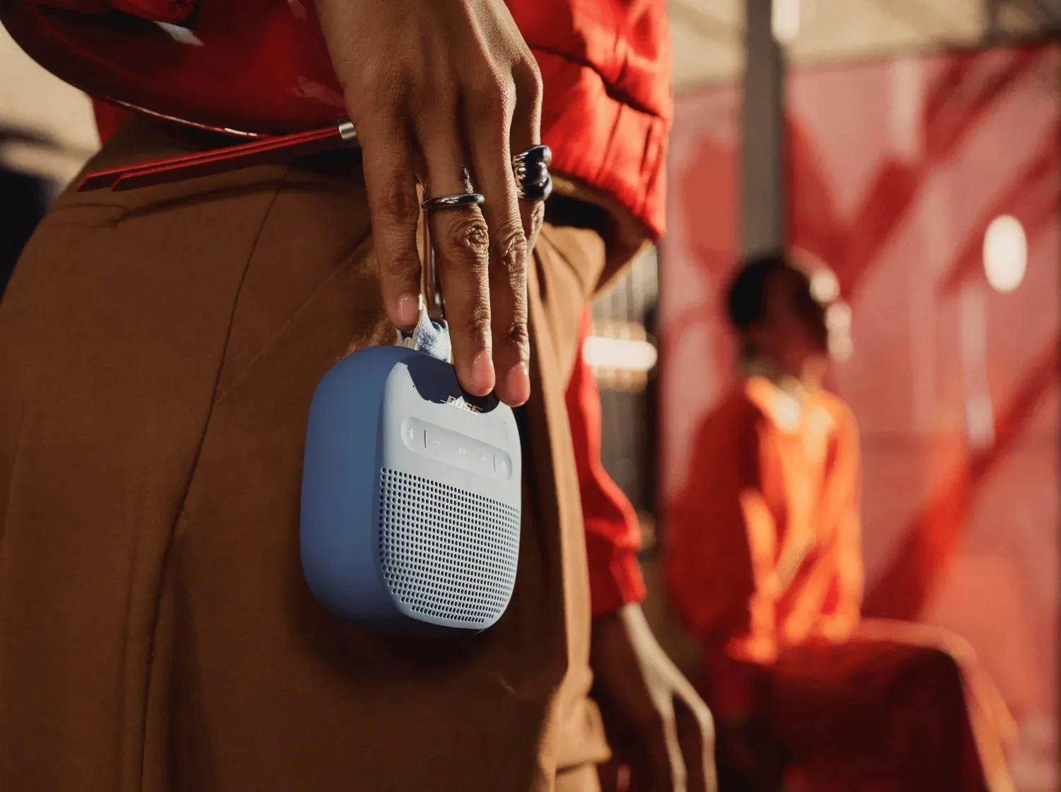 SoundLink Micro (2.ª generación) azul atardecer colgado de la mano por su correa