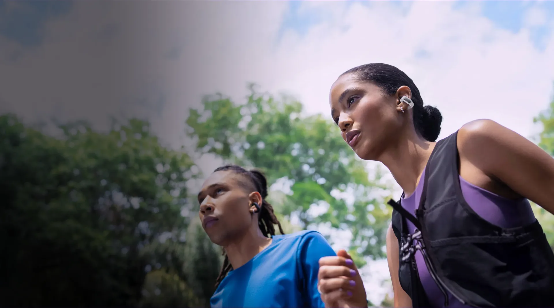 Dos personas corriendo con Bose Ultra Open Earbuds blancos