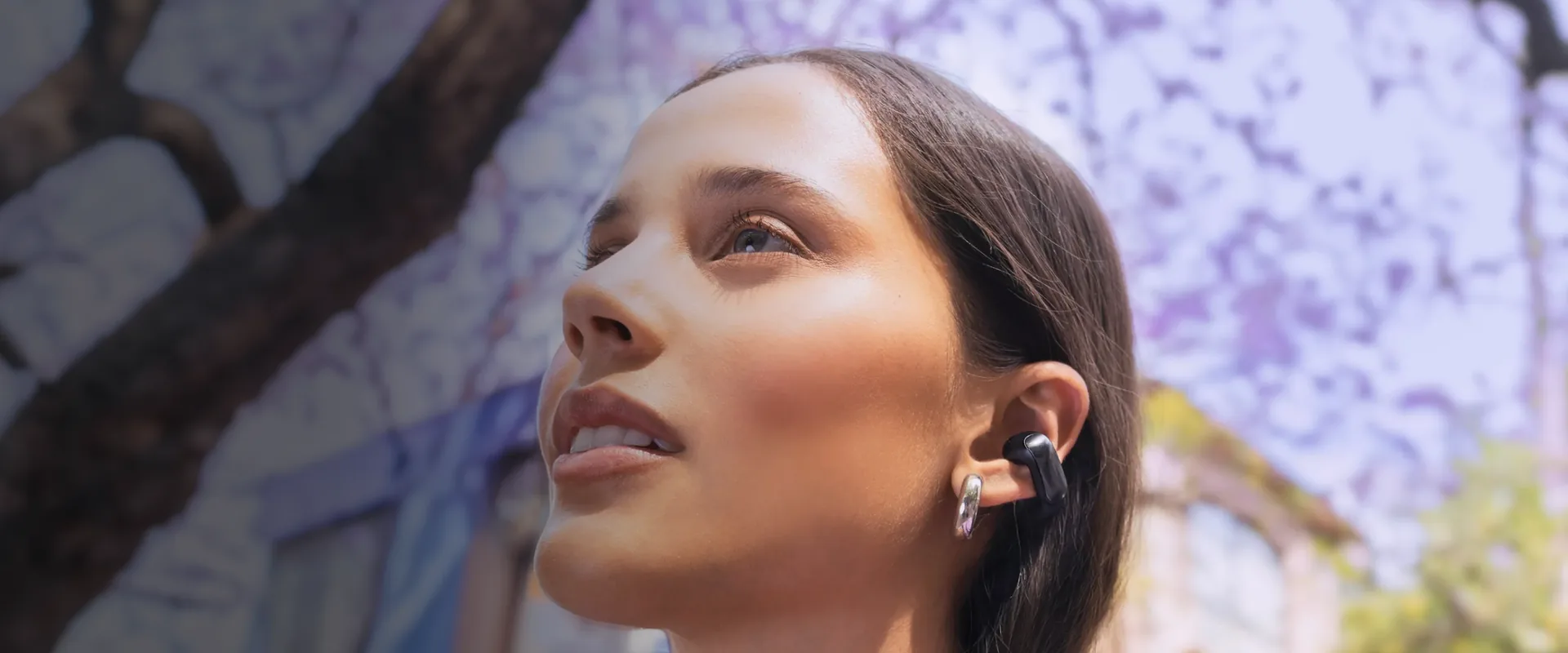 Mujer en la calle con Bose Ultra Open Earbuds negros