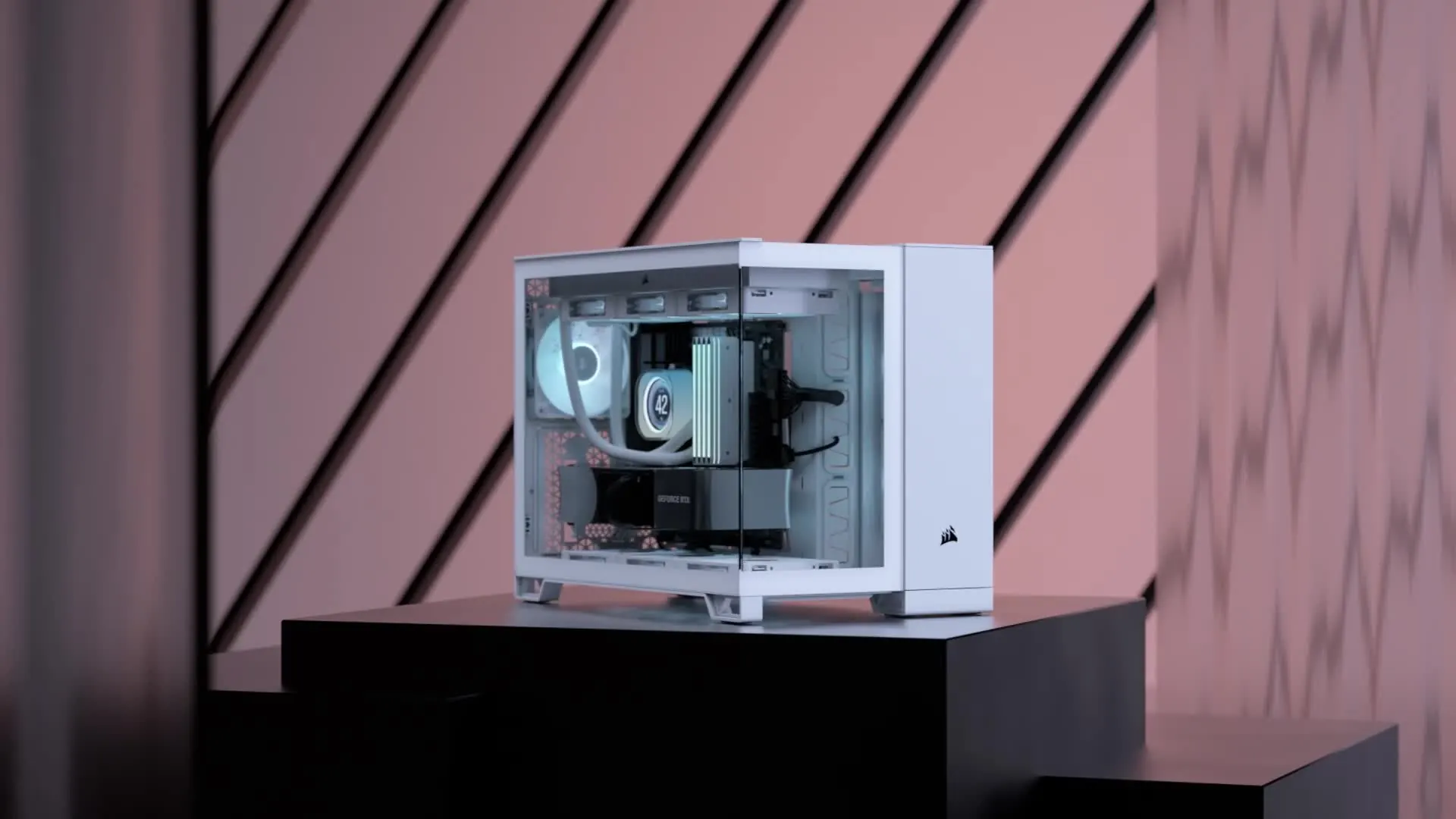 Gabinete Corsair 2500X blanco de dos cámaras sobre un pedestal con fondo de rayas