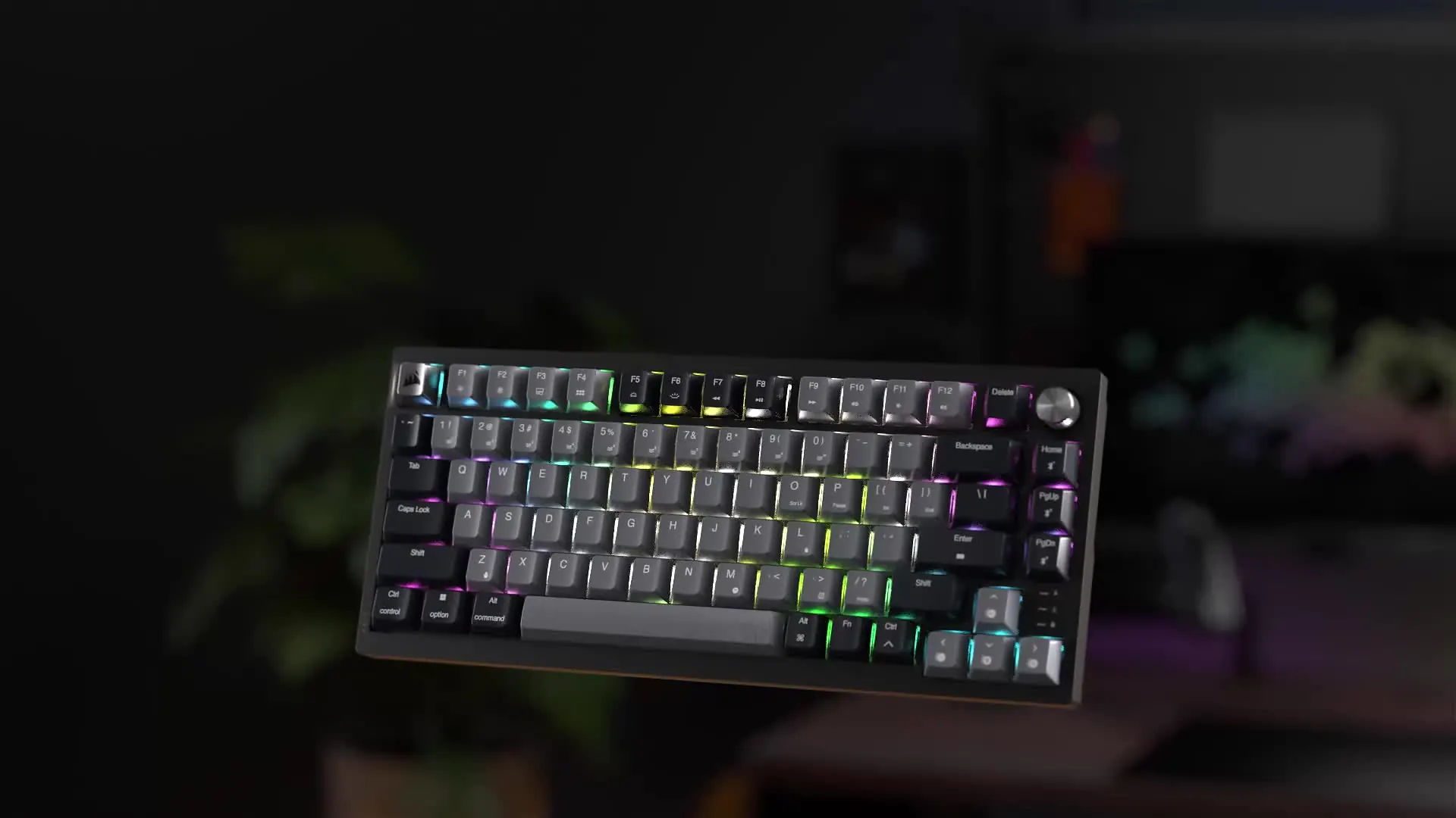 Teclado mecánico inalámbrico Corsair K65 PLUS WIRELESS 75 % con iluminación RGB flotando sobre un escritorio gamer