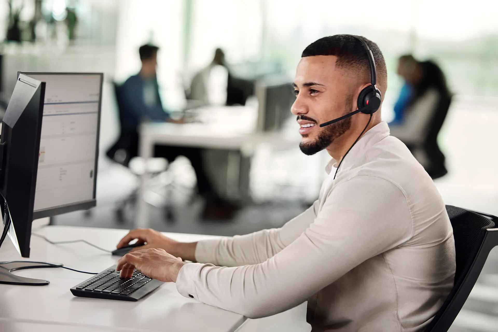Agente trabajando en la computadora con el Jabra Engage 40