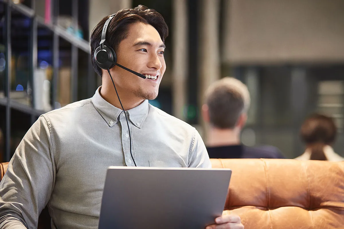 Hombre sonriendo en una llamada con los Jabra Evolve2 30 SE