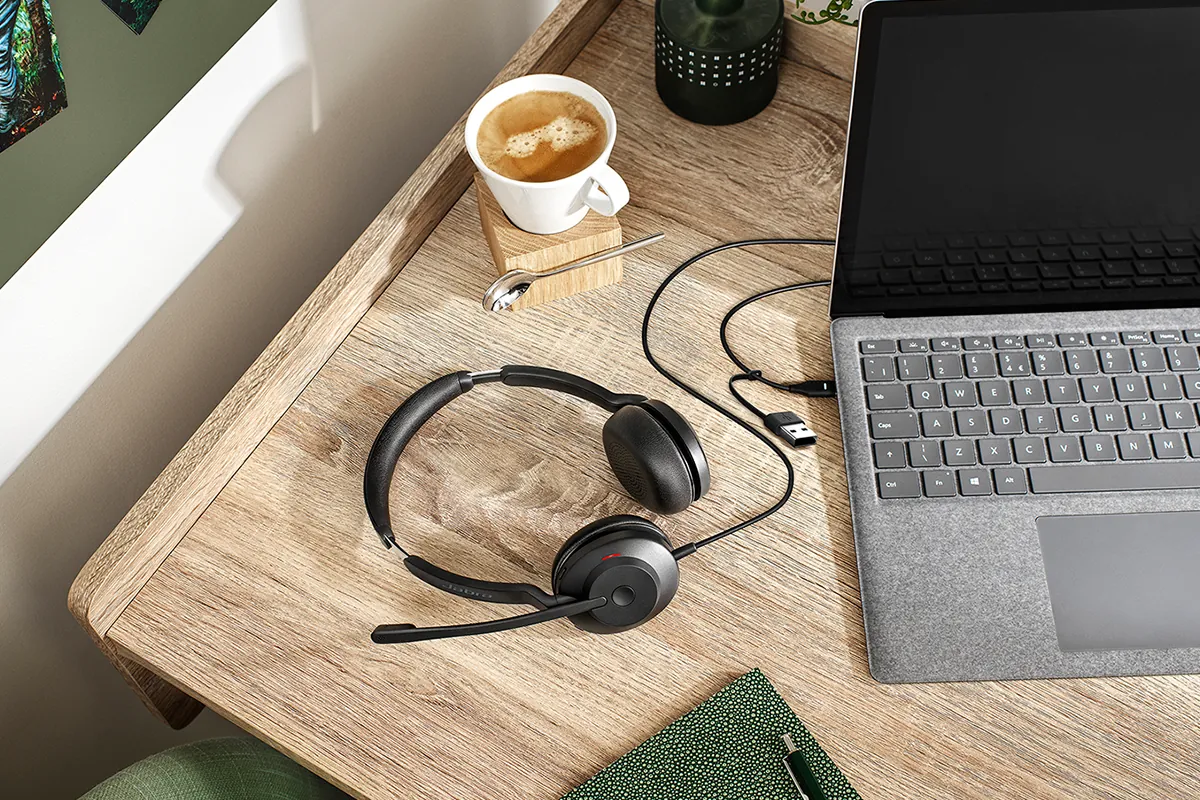 Jabra Evolve2 30 SE con su cable USB junto a una notebook