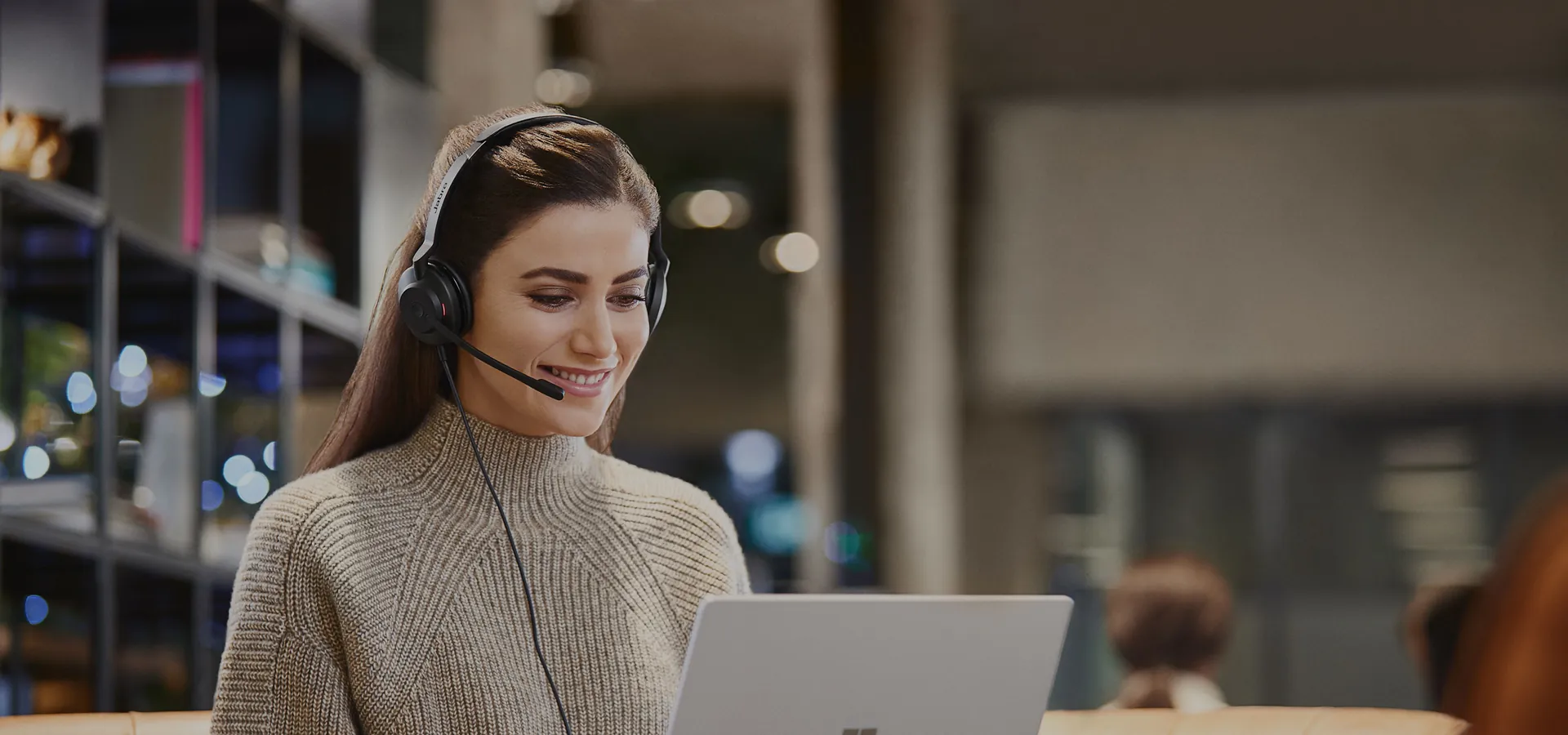 Mujer trabajando con la notebook y los Jabra Evolve2 30 SE