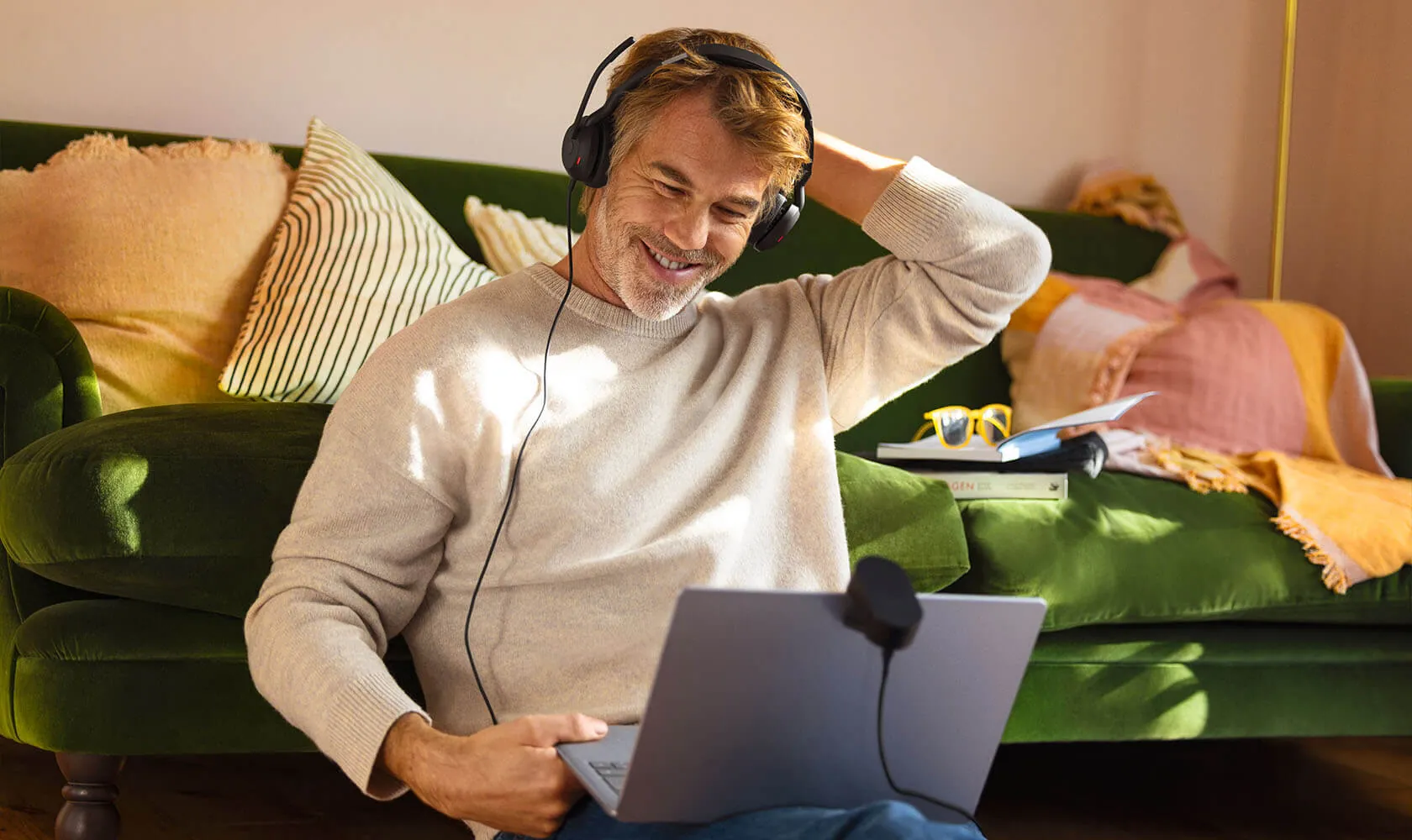 Hombre relajado en el sillón con los Jabra Evolve2 50