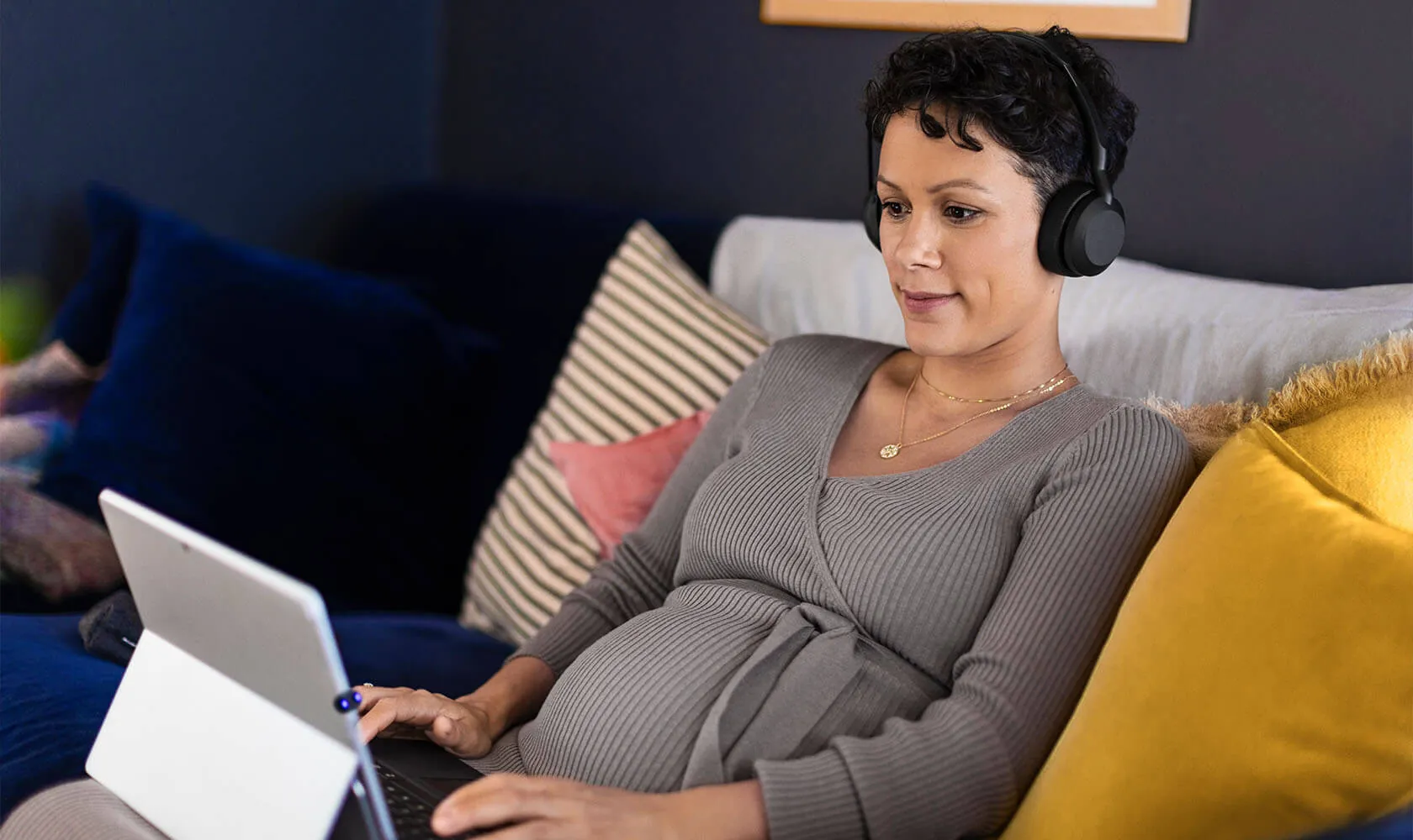 Mujer relajada en el sillón con los Jabra Evolve2 55