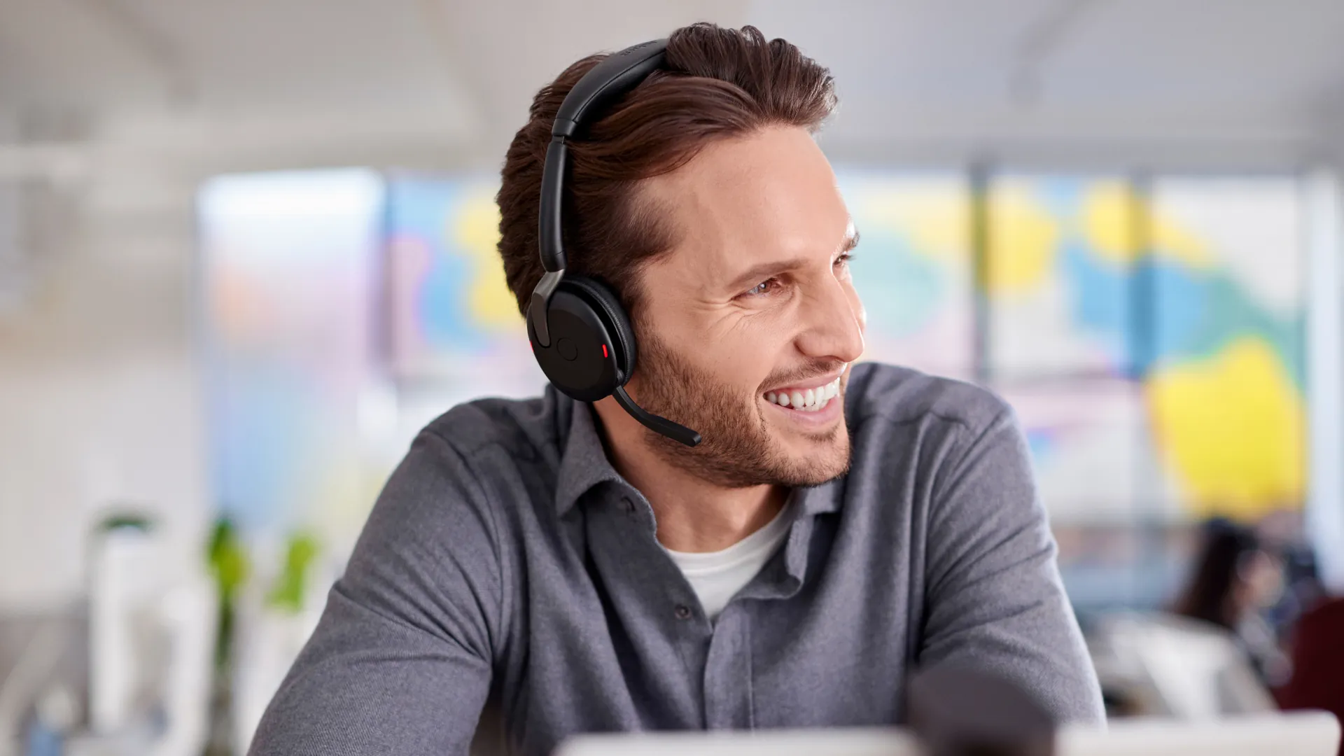 Hombre sonriendo en una videollamada con el Jabra Evolve2 65 Flex