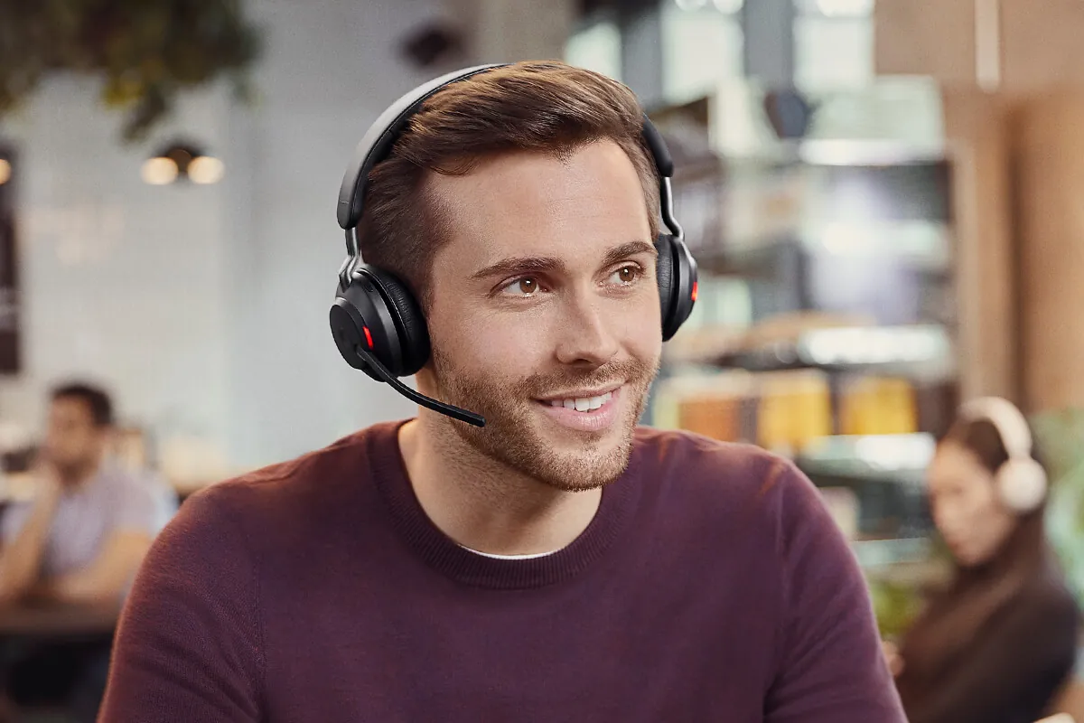 Hombre sonriendo en un bar con el Jabra Evolve2 65