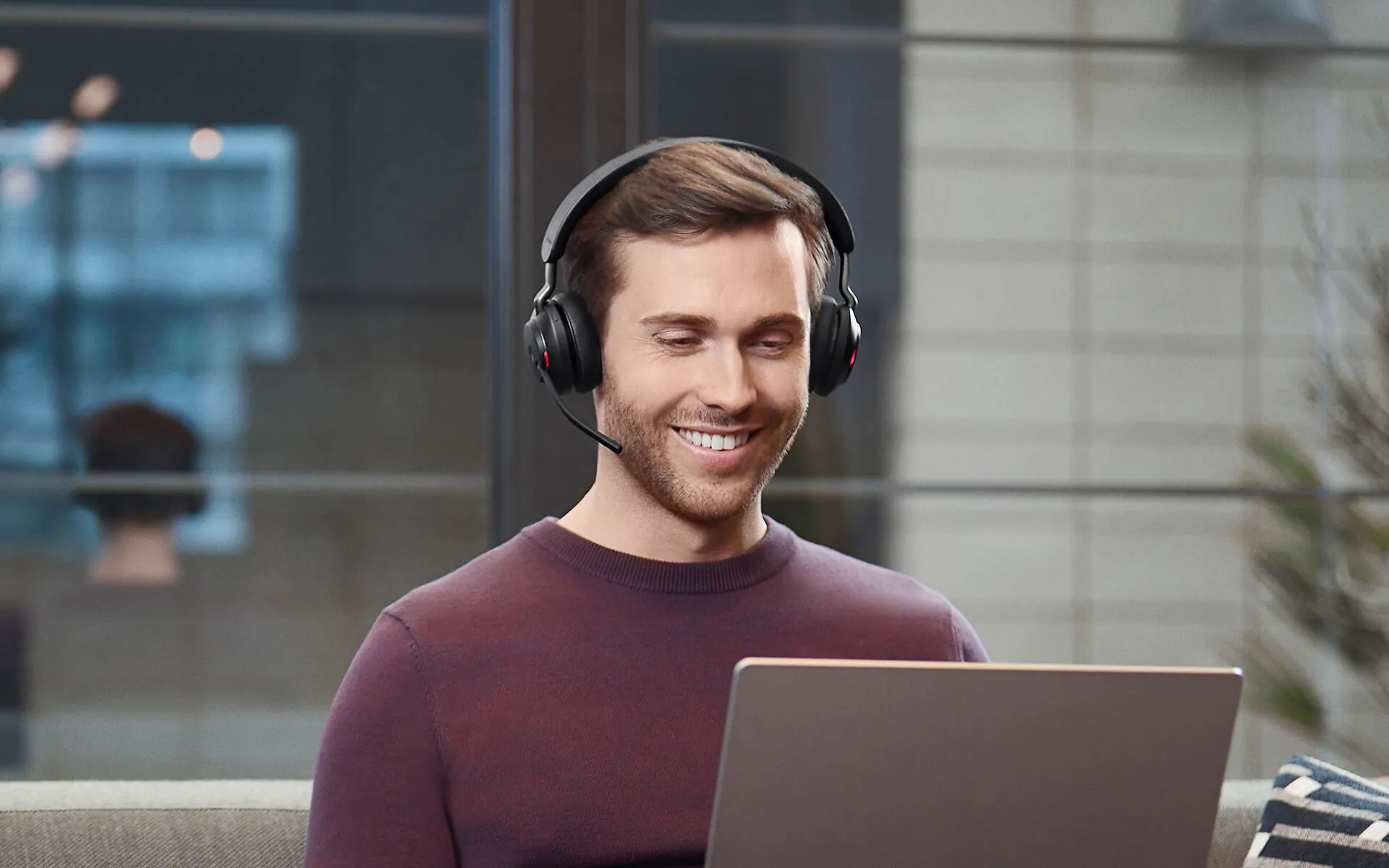 Hombre en una videollamada con la notebook y el Jabra Evolve2 65