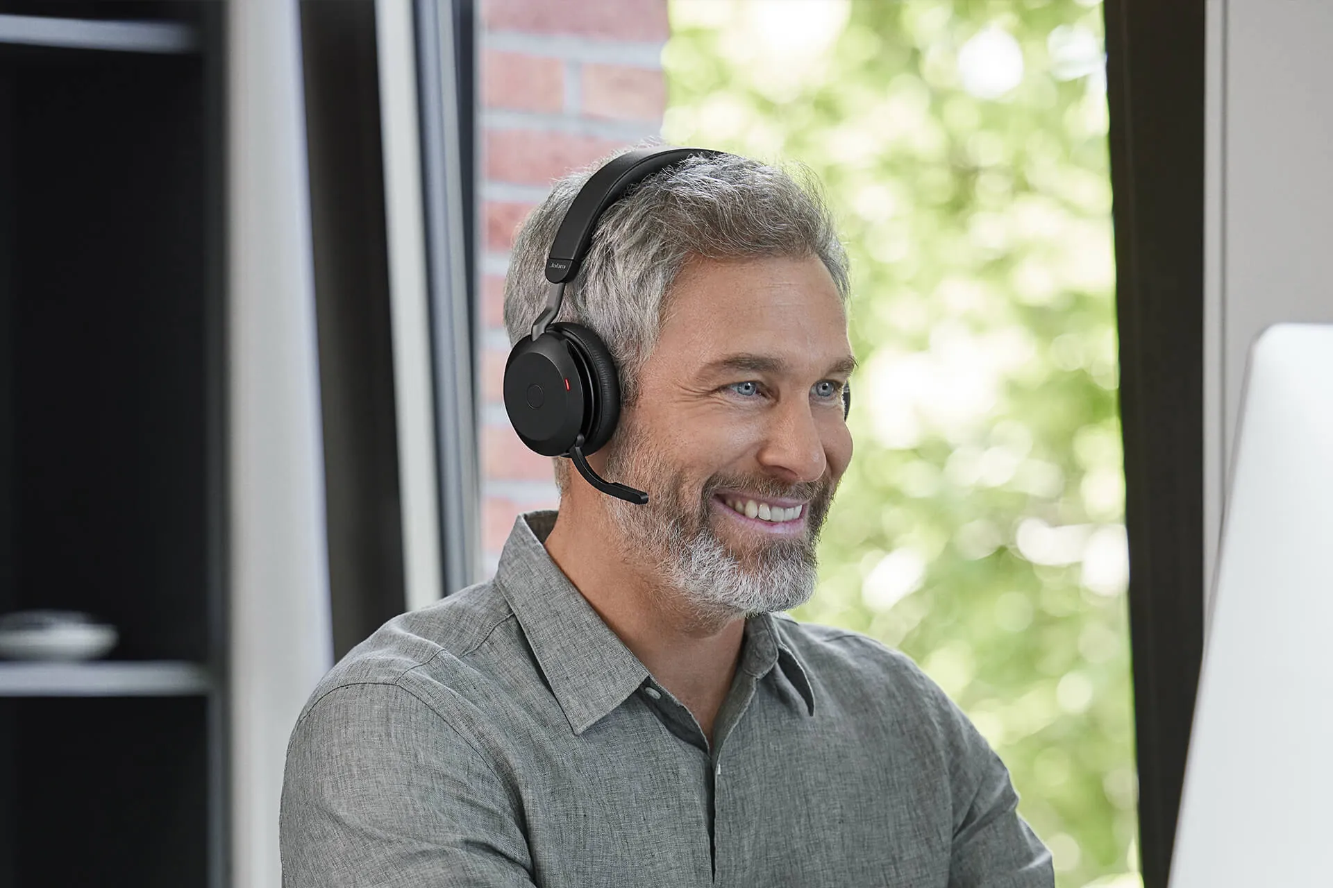 Hombre sonriendo en una videollamada con el Jabra Evolve2 75