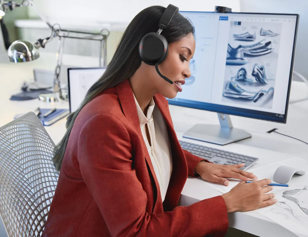 Mujer en una llamada en su escritorio con el Jabra Evolve2 75 y el brazo del micrófono bajado