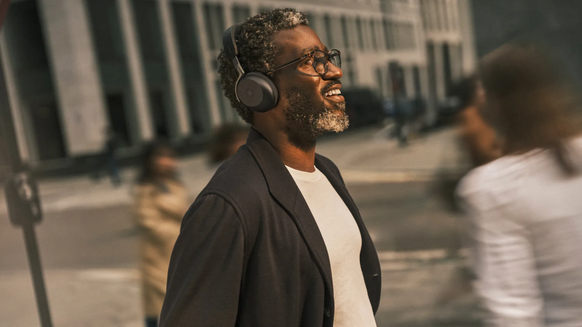 Hombre caminando por la calle con los Jabra Evolve3 75 negros
