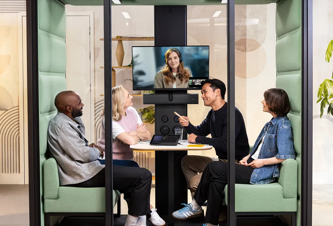 Reunión en una cabina con la PanaCast 40 VBS y una participante a distancia en la pantalla