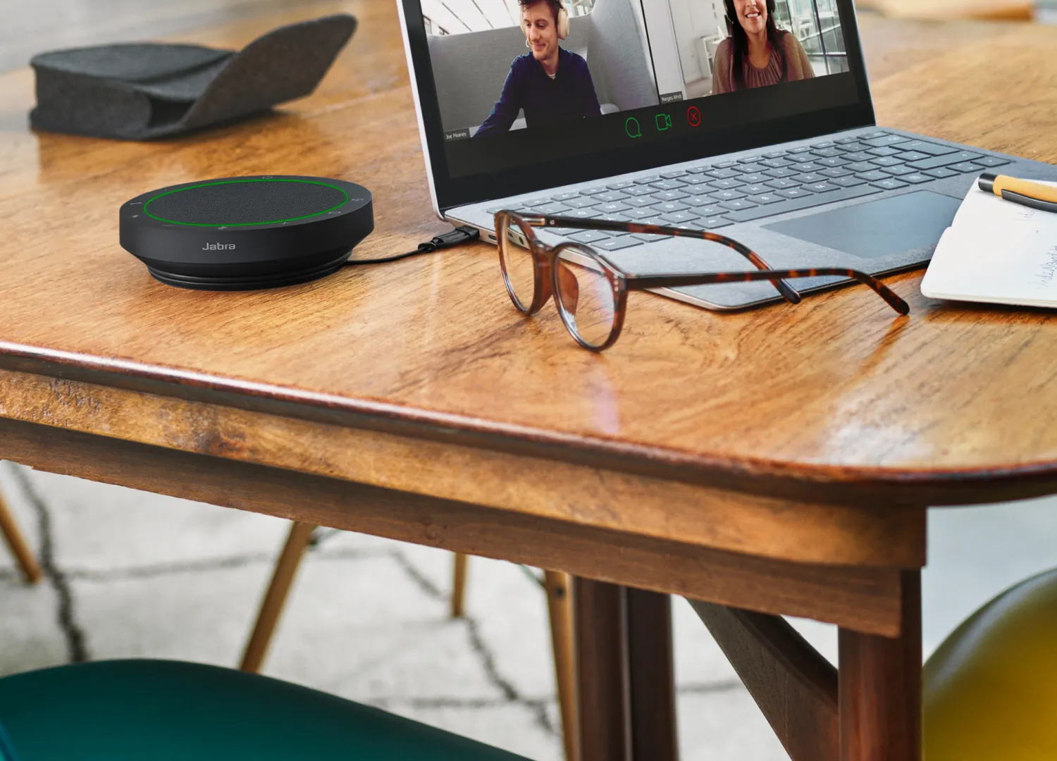 Jabra Speak2 55 conectado a una notebook, con su bolsa de transporte al lado