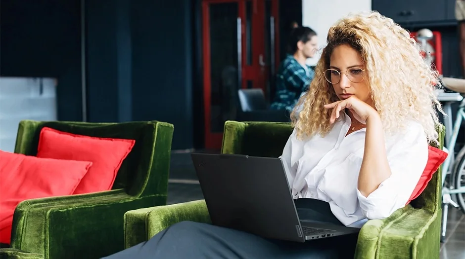 Mujer trabajando con una ThinkPad T14 Gen 6 en un sillón