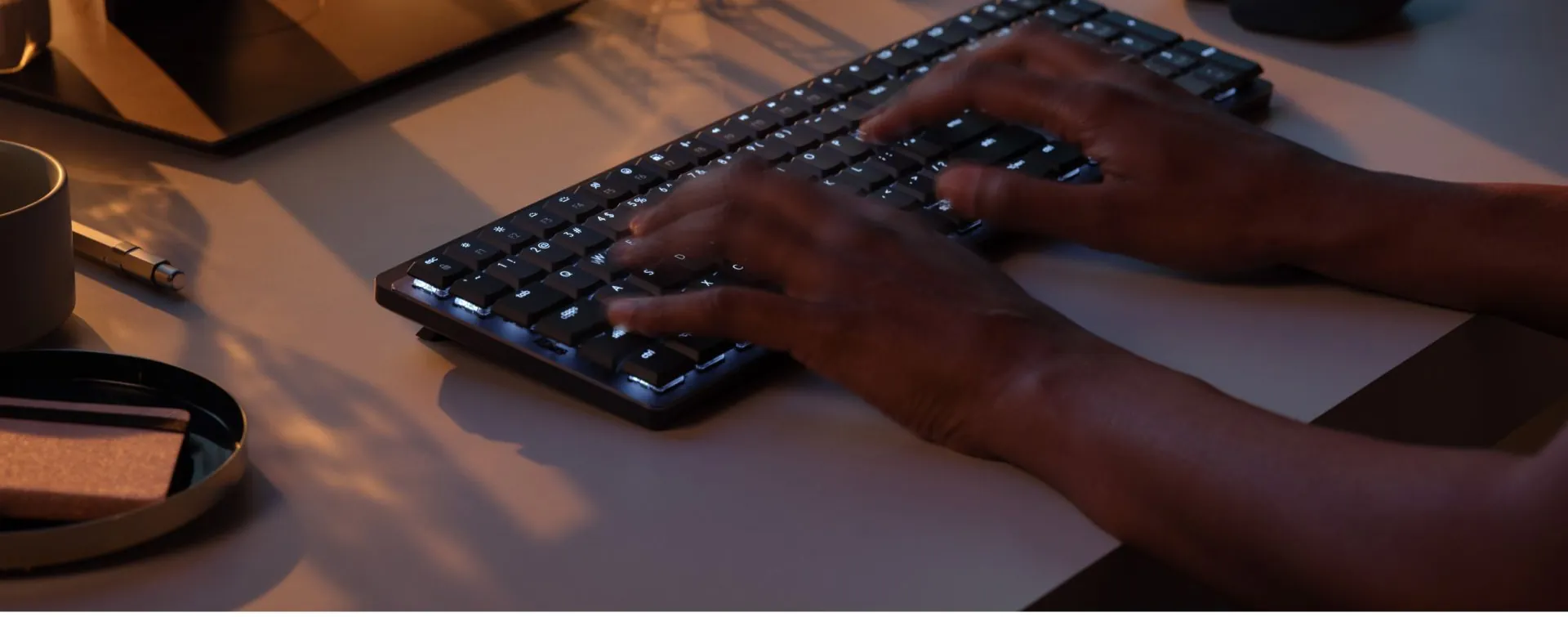 Manos escribiendo en el MX Mechanical con las teclas iluminadas