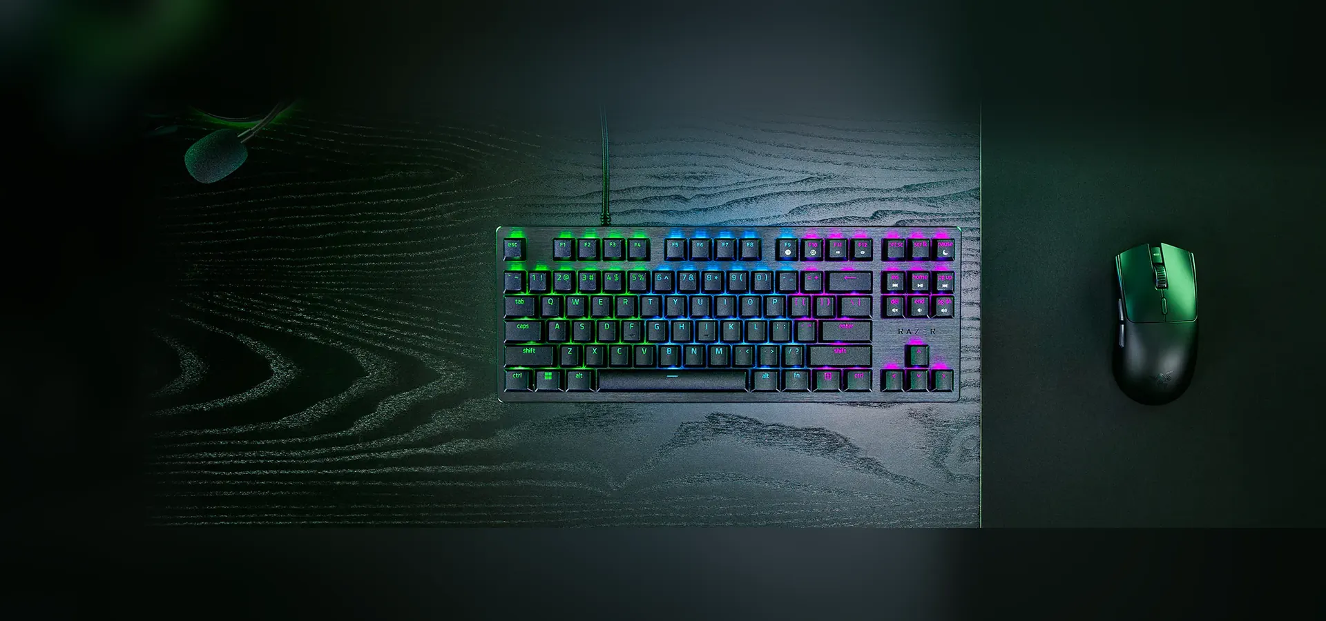 Teclado Razer Huntsman V3 X Tenkeyless sobre un escritorio de madera oscura junto a un mouse